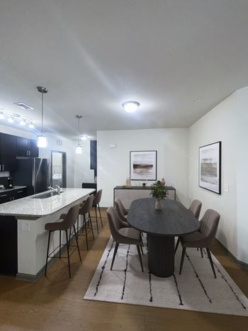 A modern dining room with a round table and chairs.